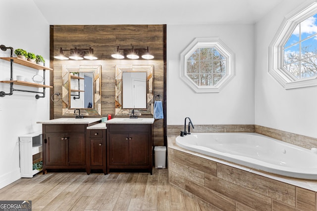 1452 Redwine Rd, Fayetteville, GA 30215 - full bathroom featuring double vanity, a garden tub, healthy amount of natural light, and wood finished floors