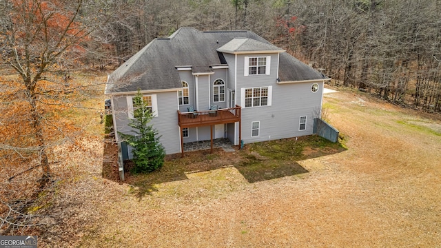 1452 Redwine Rd, Fayetteville, GA 30215 - view of front of home with a view of trees, a deck, a shingled roof, and a front lawn
