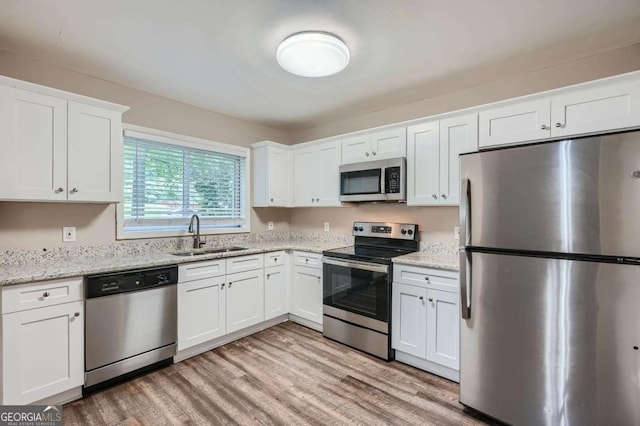 2184 Pemberton Rd SW, Atlanta, GA 30331 - kitchen featuring stainless steel appliances, light wood-type flooring, white cabinets, and light stone countertops
