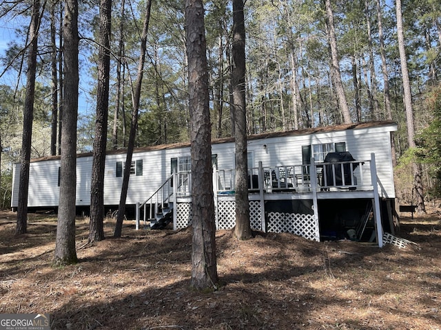 rear view of property with a wooden deck