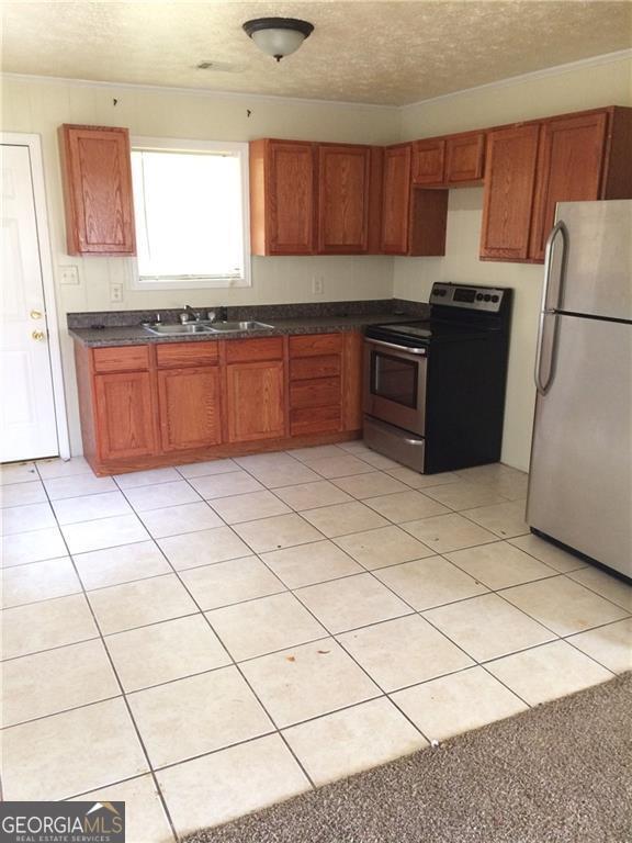 spare room with baseboards, a textured ceiling, visible vents, and light wood-type flooring