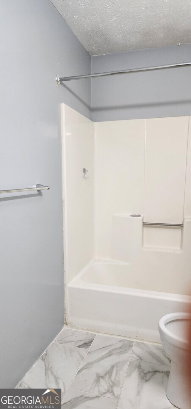 kitchen with light countertops, appliances with stainless steel finishes, under cabinet range hood, a sink, and washer / dryer