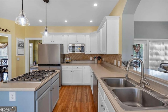 kitchen featuring a sink, white cabinets, appliances with stainless steel finishes, and tasteful backsplash