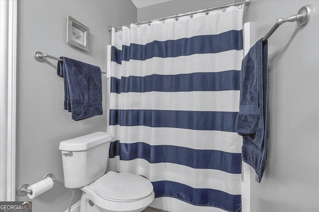 full bathroom featuring a shower with shower curtain and toilet