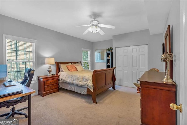 bedroom featuring light carpet, a closet, and a ceiling fan