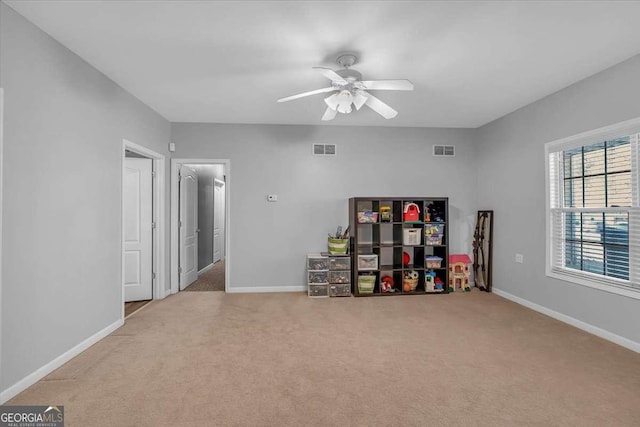 interior space with carpet flooring, baseboards, ceiling fan, and visible vents
