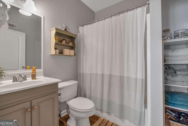 bathroom featuring visible vents, toilet, vanity, and shower / bath combo