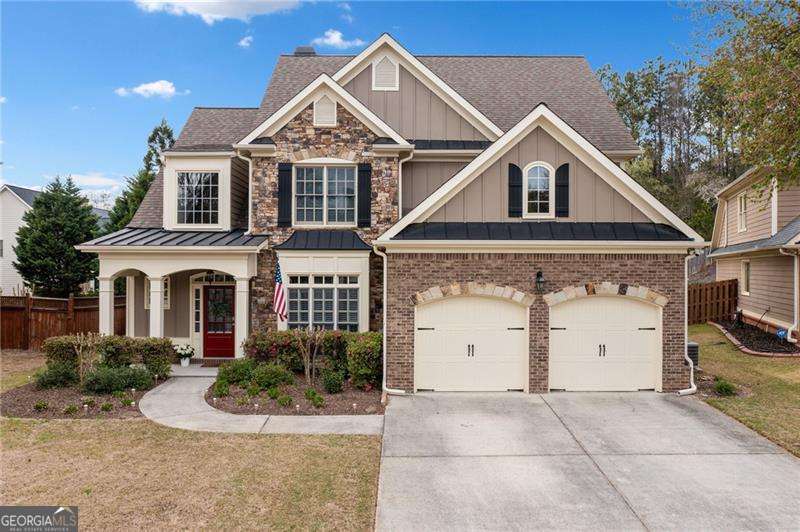 craftsman-style house with fence, a garage, concrete driveway, brick siding, and board and batten siding