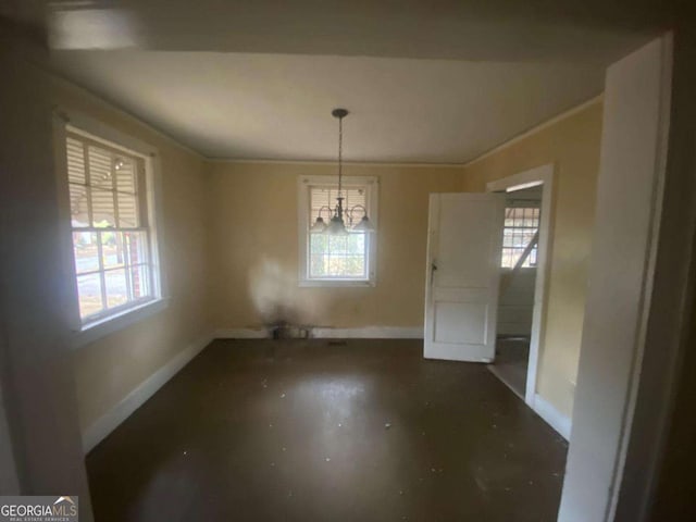 unfurnished dining area with ornamental molding, a notable chandelier, and a wealth of natural light
