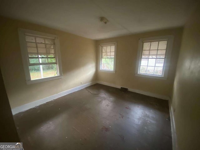 empty room with plenty of natural light and baseboards
