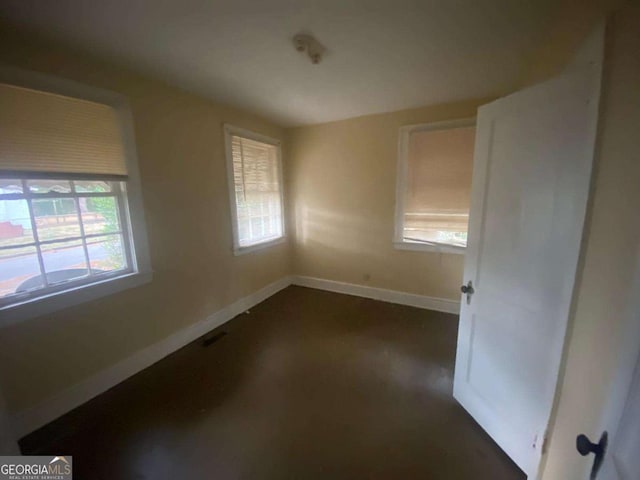 unfurnished room with baseboards and visible vents