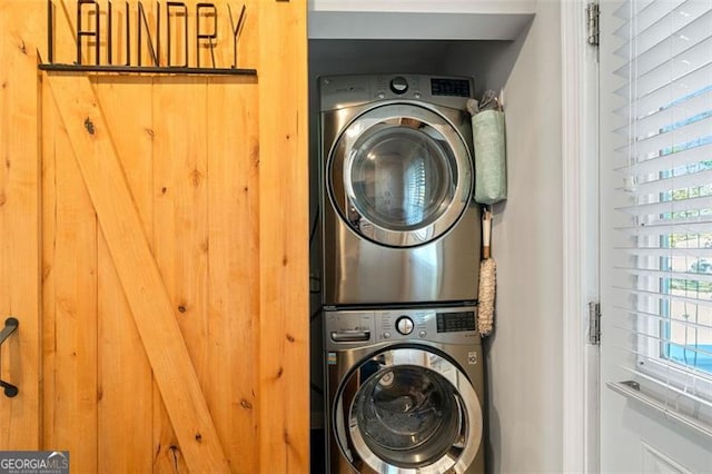 washroom featuring stacked washer / drying machine and laundry area