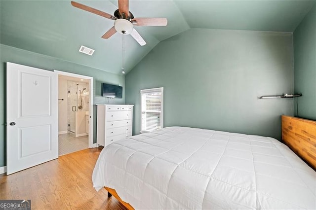 bedroom with visible vents, connected bathroom, ceiling fan, wood finished floors, and vaulted ceiling