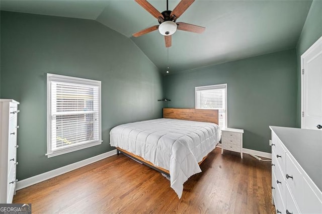 bedroom with baseboards, vaulted ceiling, a ceiling fan, and dark wood-style flooring
