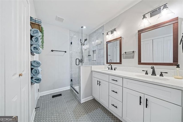 full bathroom with a shower stall, double vanity, visible vents, and a sink