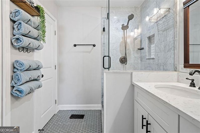 bathroom featuring a stall shower, baseboards, and vanity
