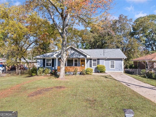 view of front of property featuring concrete driveway, fence, and a front lawn