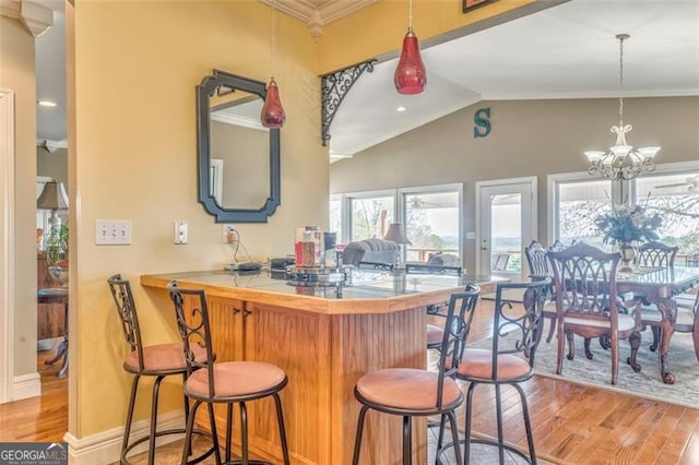 300 Ellis Rd, Rome, GA 30161 - bar featuring crown molding, decorative light fixtures, light wood-style floors, vaulted ceiling, and a notable chandelier