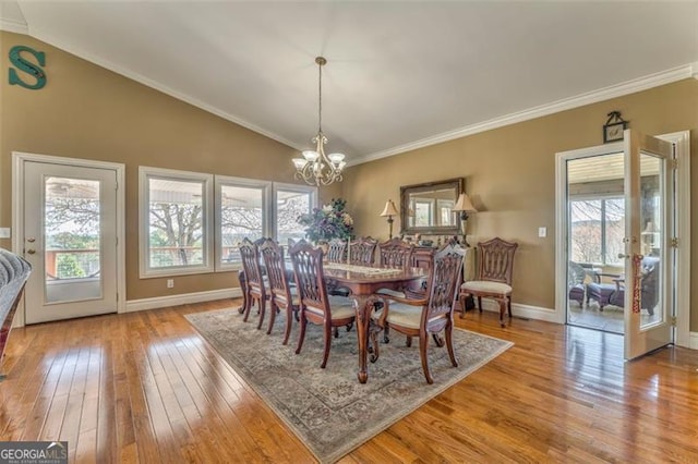 300 Ellis Rd, Rome, GA 30161 - dining room with crown molding, baseboards, lofted ceiling, a notable chandelier, and wood-type flooring