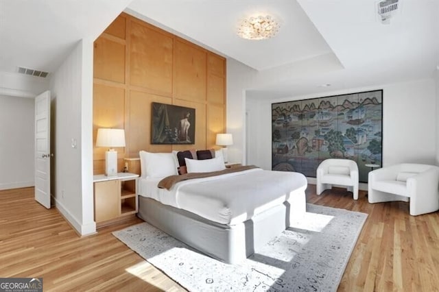 bedroom featuring light wood finished floors, baseboards, and visible vents