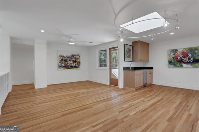interior space with baseboards, dishwasher, ceiling fan, recessed lighting, and light wood-style flooring