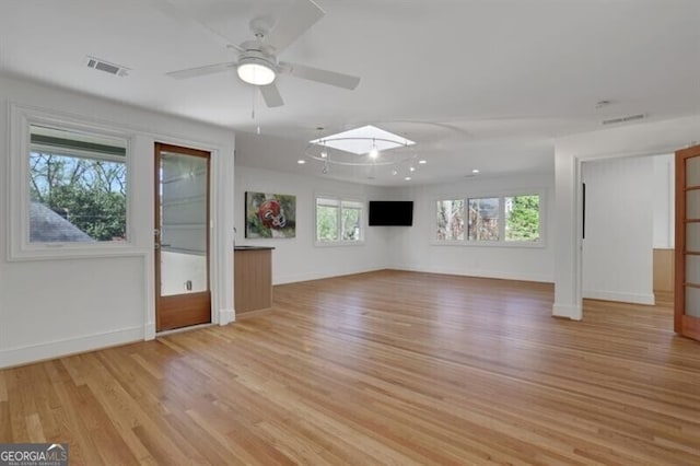 unfurnished living room with light wood finished floors, visible vents, baseboards, and a ceiling fan