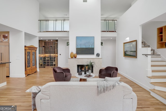 living room with stairs, a high ceiling, and wood finished floors