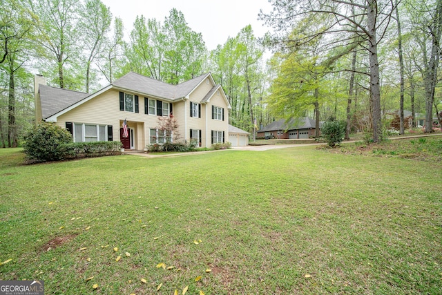 colonial house with a garage, a front yard, a chimney, and concrete driveway
