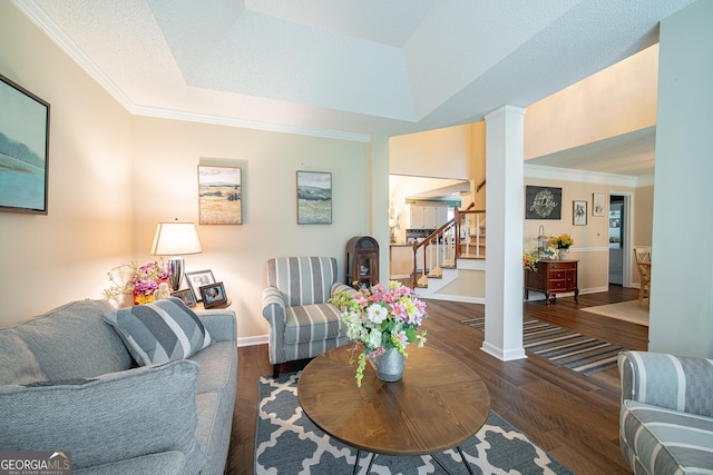 living room featuring stairway, crown molding, wood finished floors, baseboards, and a tray ceiling