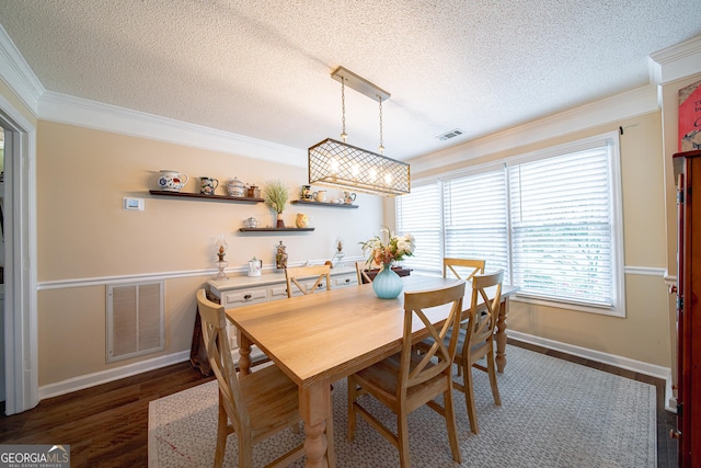 dining space featuring crown molding, a textured ceiling, baseboards, and wood finished floors