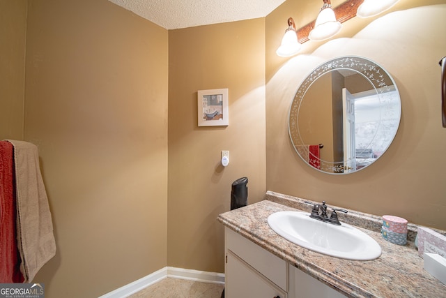 bathroom with vanity, a textured ceiling, tile patterned floors, and baseboards