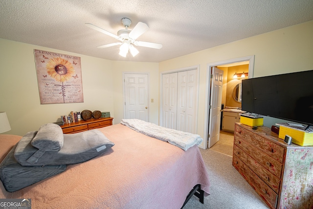 bedroom featuring light colored carpet, a closet, a ceiling fan, ensuite bath, and a textured ceiling