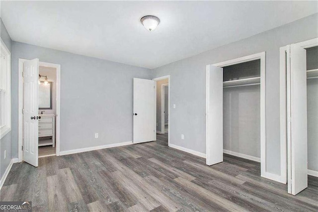 3862 Northstrand Dr, Decatur, GA 30035 - unfurnished bedroom with baseboards, connected bathroom, wood finished floors, and two closets