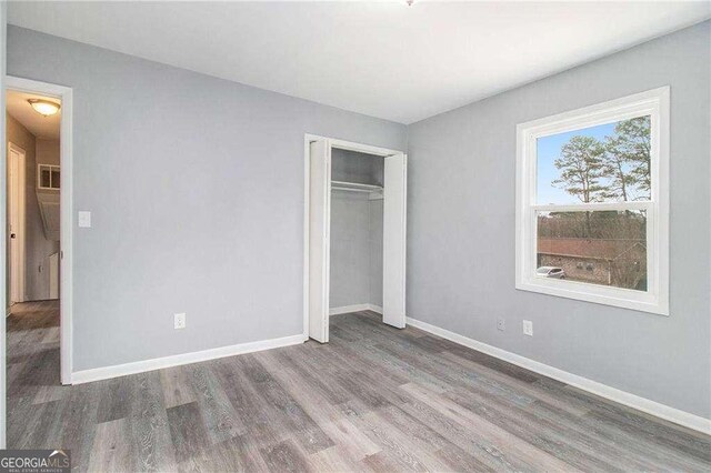 3862 Northstrand Dr, Decatur, GA 30035 - unfurnished bedroom with a closet, baseboards, visible vents, and wood finished floors