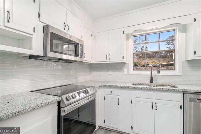 3862 Northstrand Dr, Decatur, GA 30035 - kitchen featuring white cabinetry, stainless steel appliances, decorative backsplash, a sink, and light stone countertops