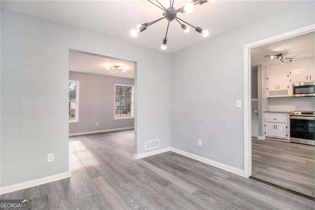 3862 Northstrand Dr, Decatur, GA 30035 - interior space featuring baseboards, visible vents, wood finished floors, and a chandelier