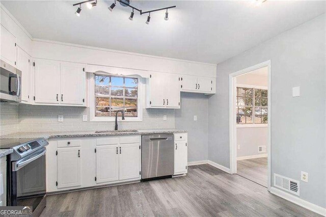 3862 Northstrand Dr, Decatur, GA 30035 - kitchen with a sink, visible vents, white cabinets, appliances with stainless steel finishes, and wood finished floors