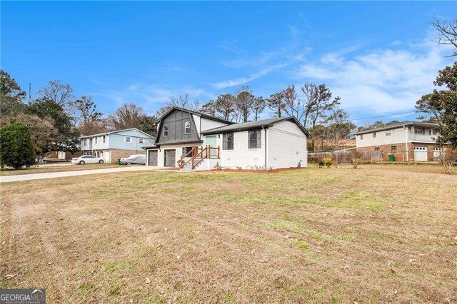 3862 Northstrand Dr, Decatur, GA 30035 - view of front of house featuring driveway, a garage, a front lawn, and fence