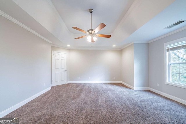 carpeted empty room with a ceiling fan, ornamental molding, baseboards, and visible vents