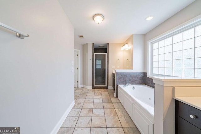 bathroom featuring vanity, a shower stall, a whirlpool tub, baseboards, and visible vents