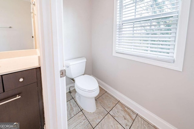 bathroom with toilet, tile patterned floors, vanity, and plenty of natural light