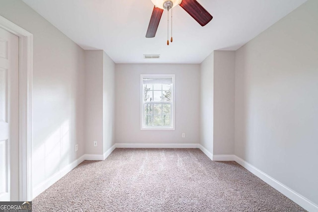 carpeted empty room featuring visible vents, baseboards, and ceiling fan