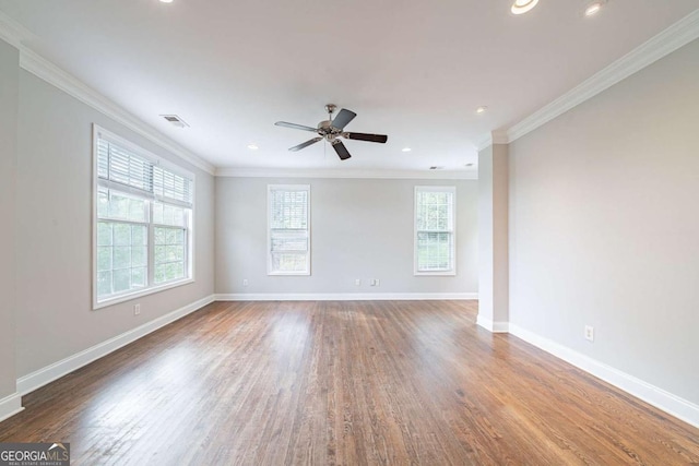spare room featuring visible vents, crown molding, baseboards, ceiling fan, and wood finished floors