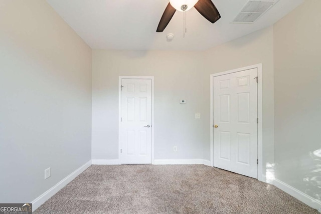 unfurnished bedroom with carpet flooring, baseboards, ceiling fan, and visible vents