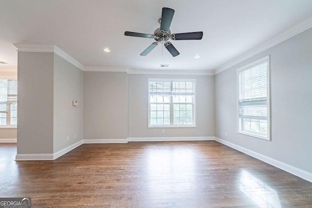 unfurnished room featuring baseboards, a wealth of natural light, crown molding, and dark wood finished floors