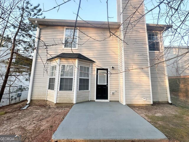 rear view of property with fence and a patio