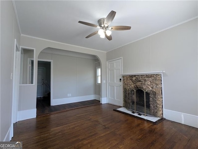 unfurnished living room with arched walkways, a fireplace, ceiling fan, and wood finished floors