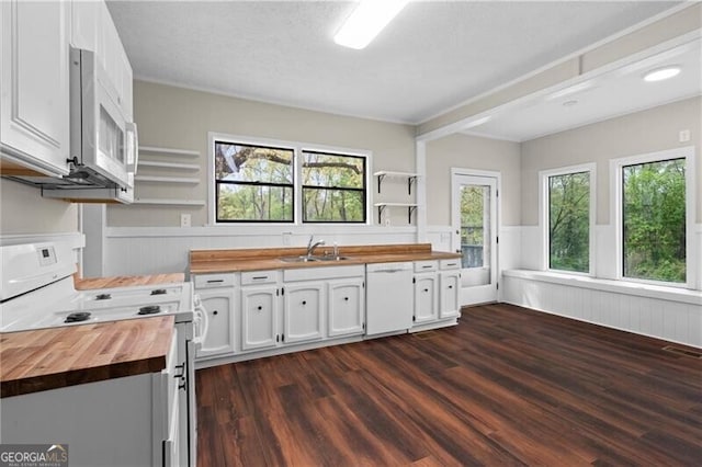 kitchen with butcher block countertops, a wainscoted wall, open shelves, and white appliances