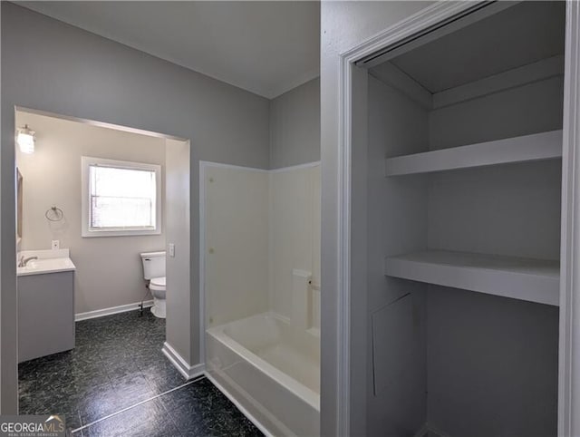 full bathroom with toilet, vanity, and baseboards