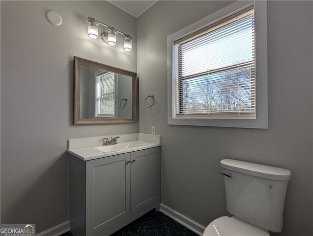 half bath featuring toilet, baseboards, marble finish floor, and vanity